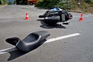 Motorcycle lying on the road with traffic cones after a crash, representing motorcycle accident matters at Welcome Law Firm in Bridgeport